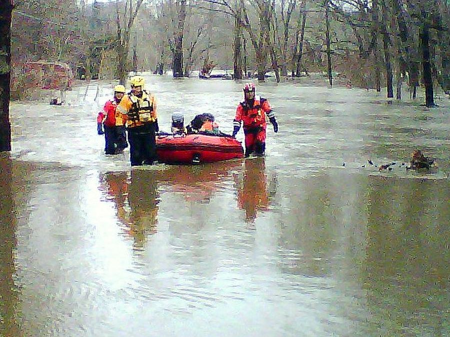 Rescue team moving through floodwater with a boat