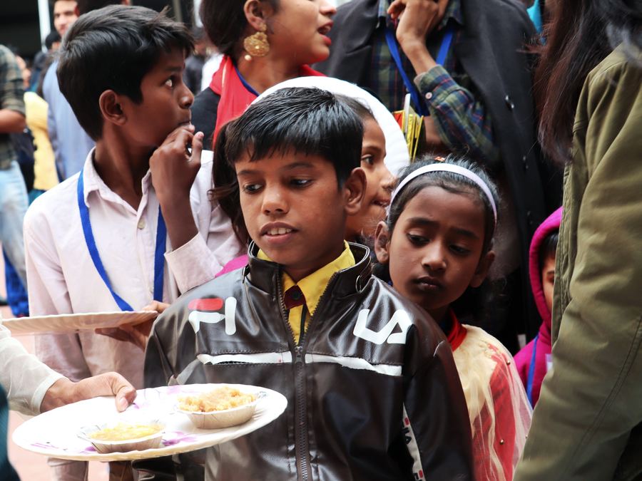 Children receiving plates of hot food