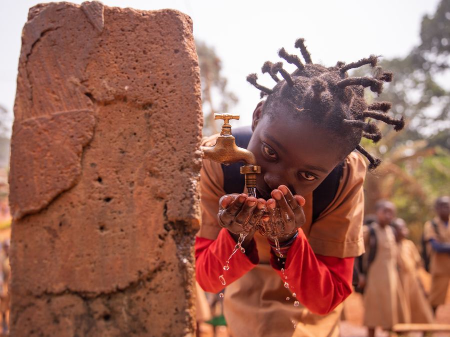 A child in Somalia drinking from a tap
