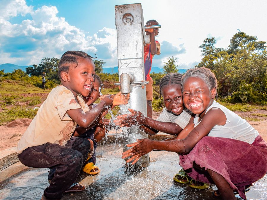 Children rejoicing at a water well