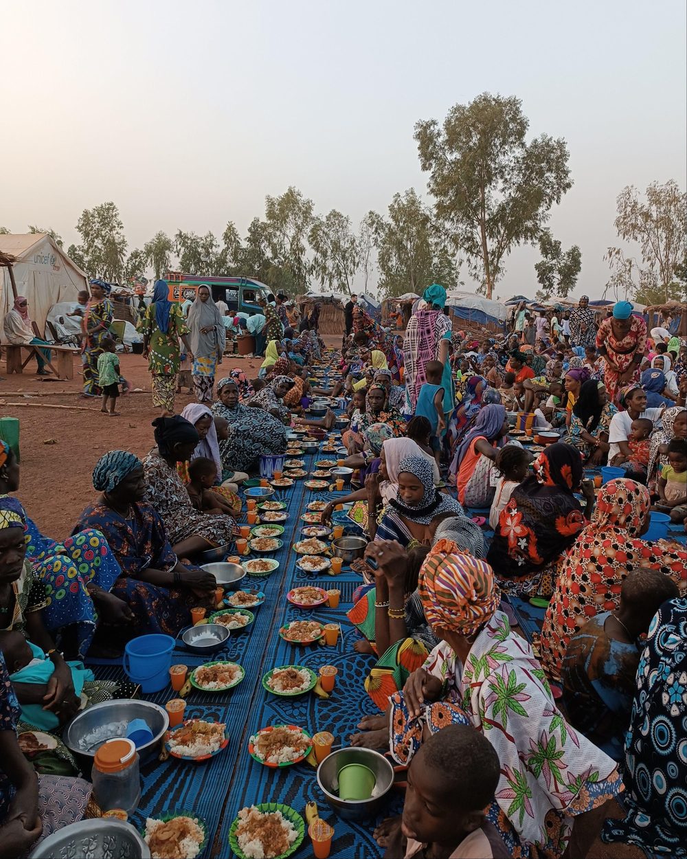 Hot meals served to hundreds of people seated on mats