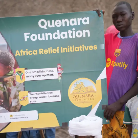 Sahada Quenara Foundation afişinin yanında aileler